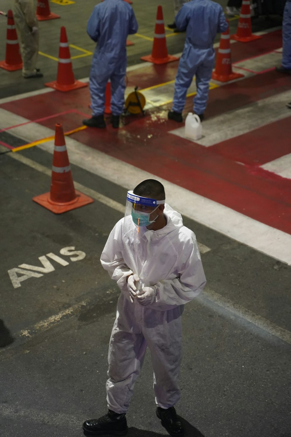 man in white long sleeve shirt wearing white helmet standing on gray concrete floor