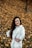 woman in white dress shirt standing on dried leaves