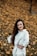 woman in white dress shirt standing on dried leaves