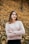 woman in gray sweater standing on brown leaves during daytime