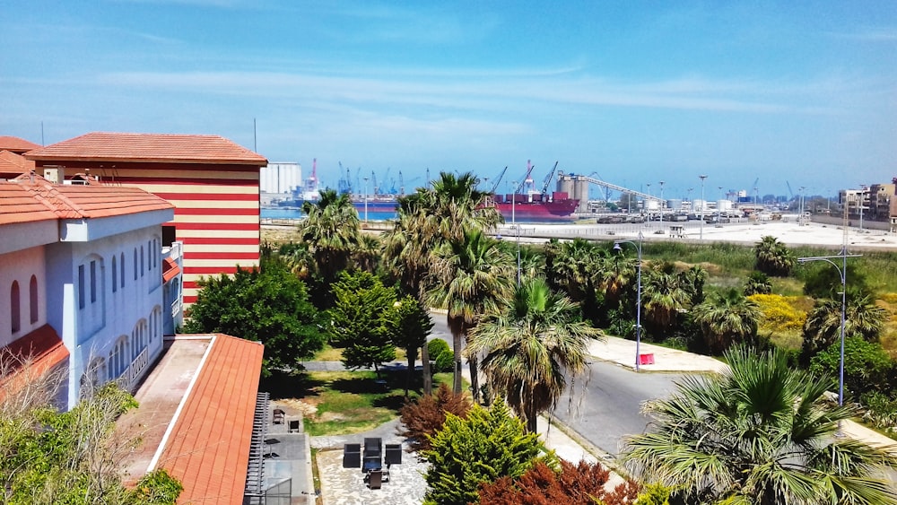 red and white ship on sea near green palm trees during daytime