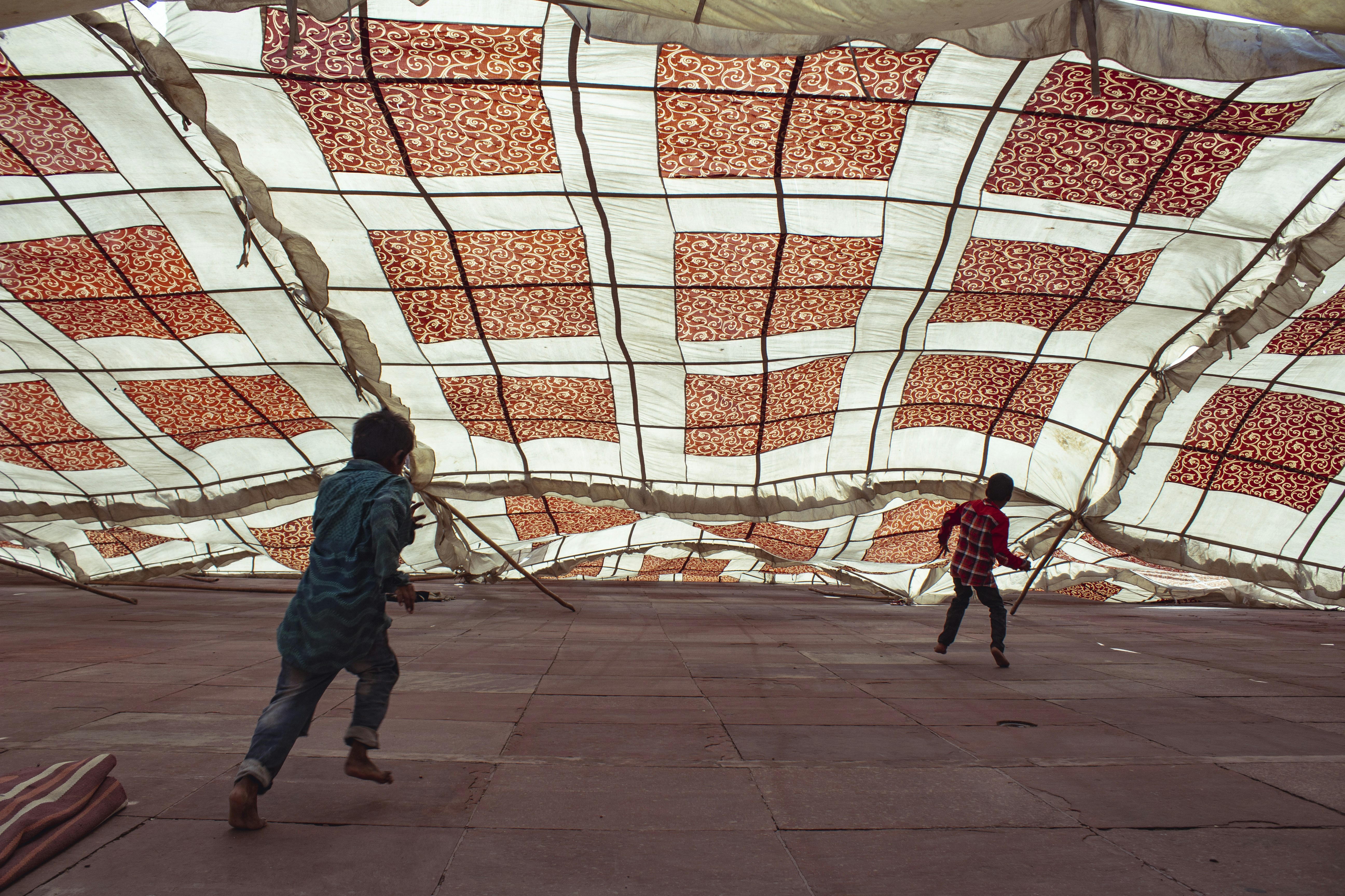 man in blue jacket walking on gray concrete pavement