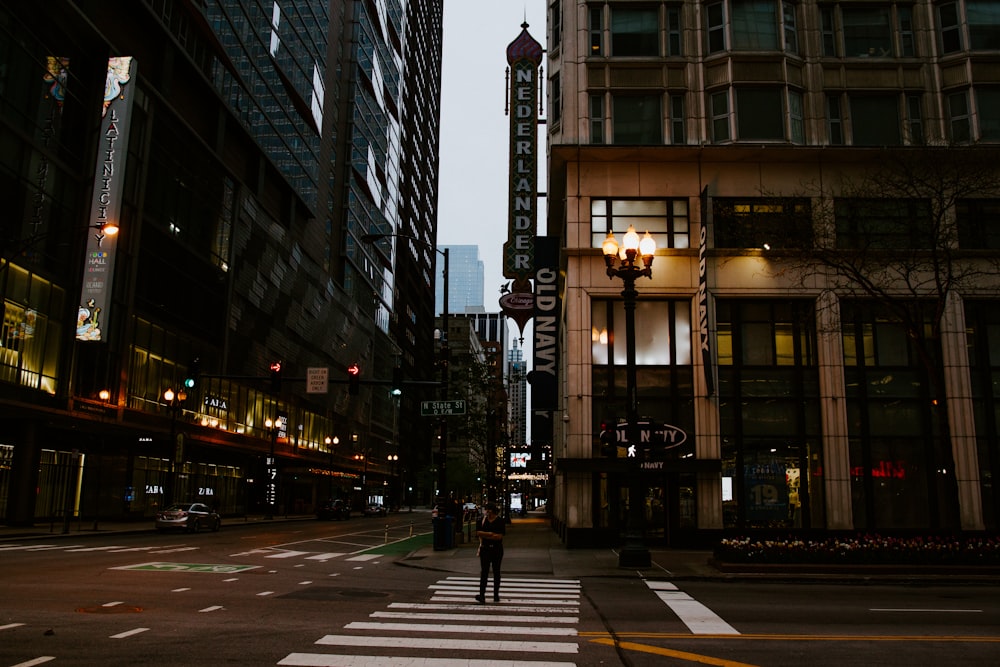 people walking on pedestrian lane in between high rise buildings during nighttime