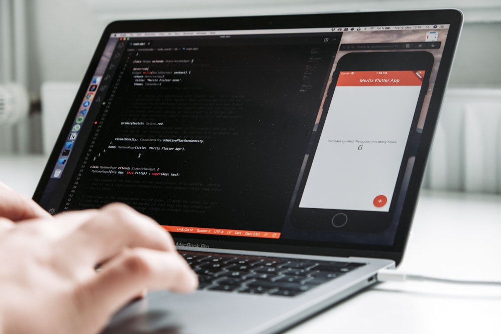 person using macbook pro on white table