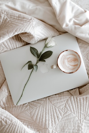 A calm morning scene with a laptop, notebook, and soft blanket nearby