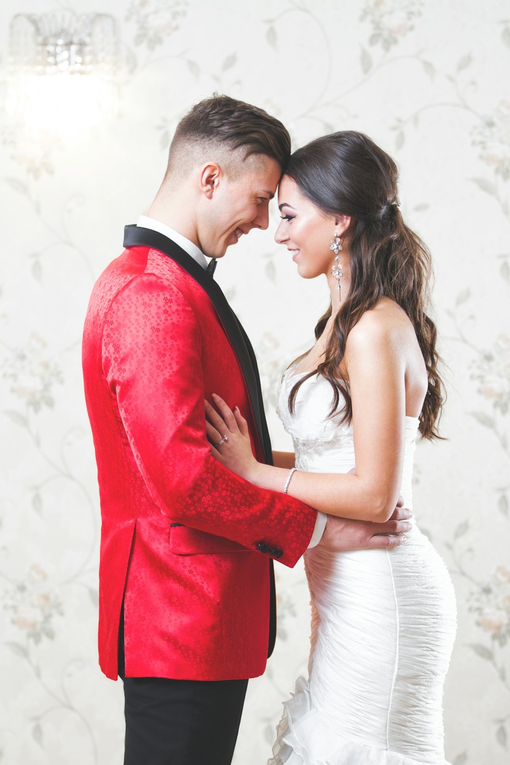 man in red suit kissing woman in white dress