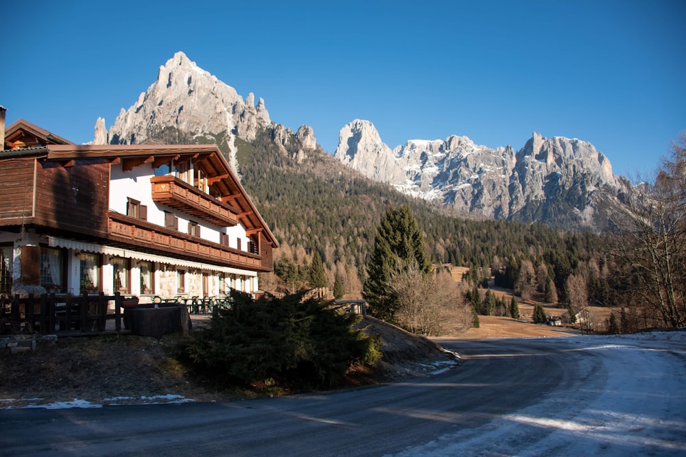 brown and white house near green trees and mountain during daytime