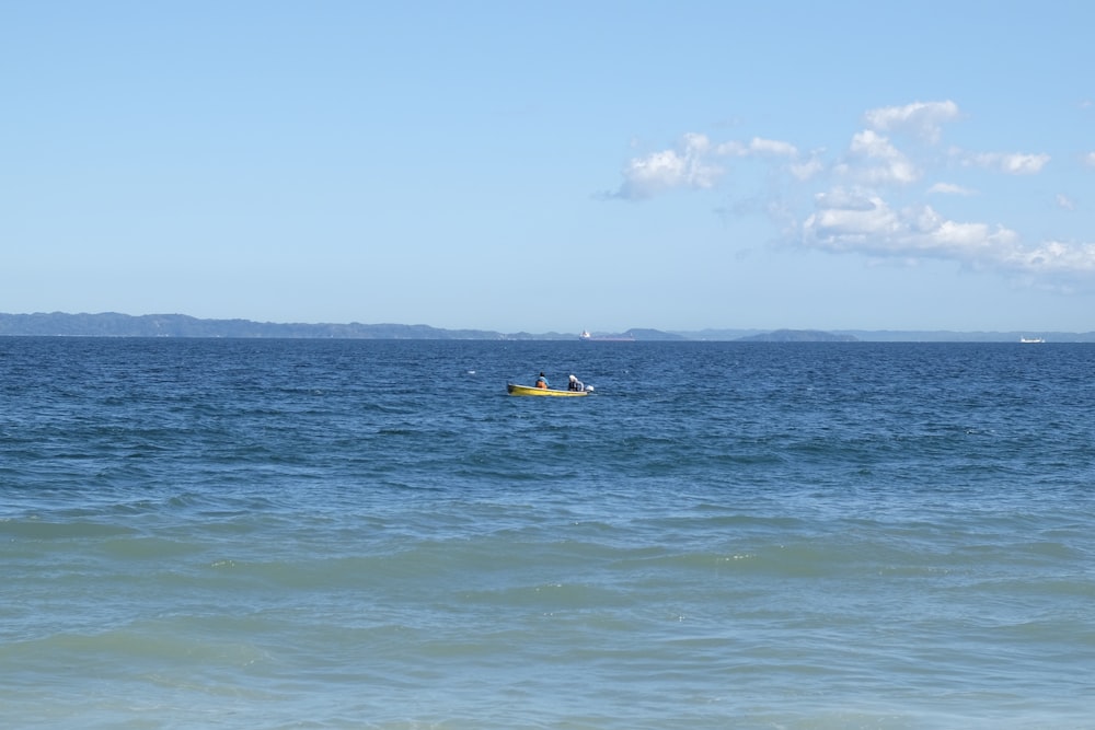 Barca gialla e nera in mare durante il giorno