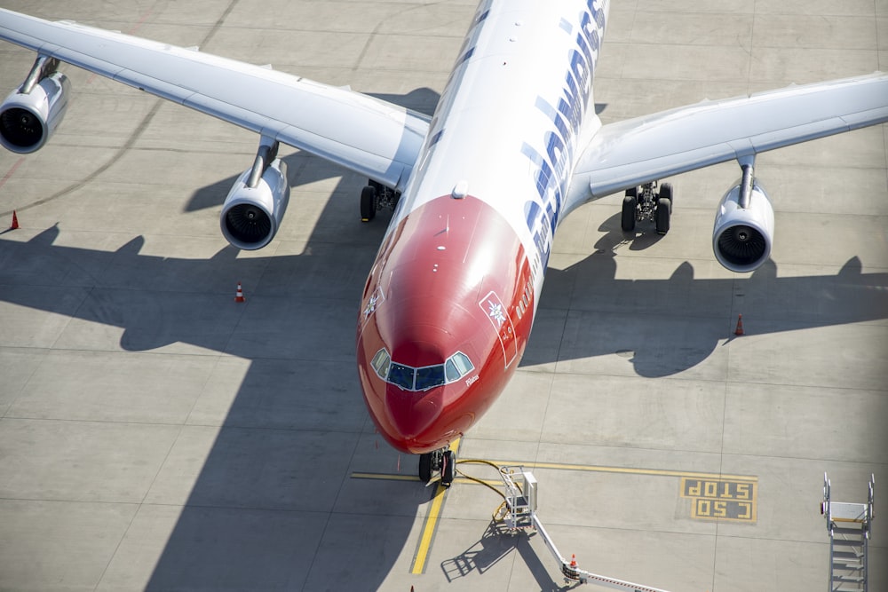 Avión blanco y rojo en el aeropuerto durante el día