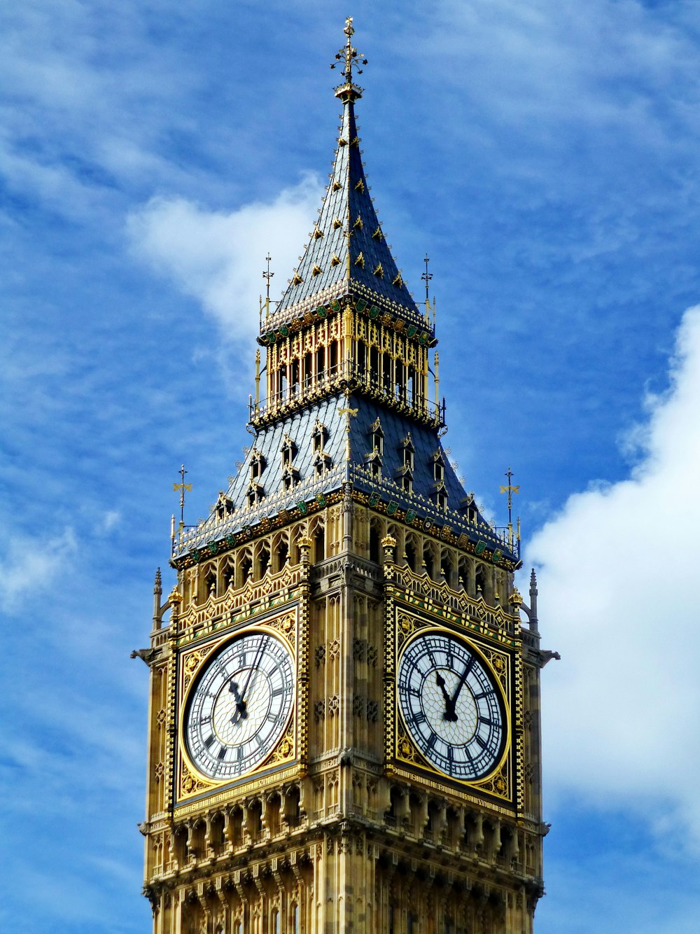 torre dell'orologio marrone e bianca sotto il cielo blu durante il giorno