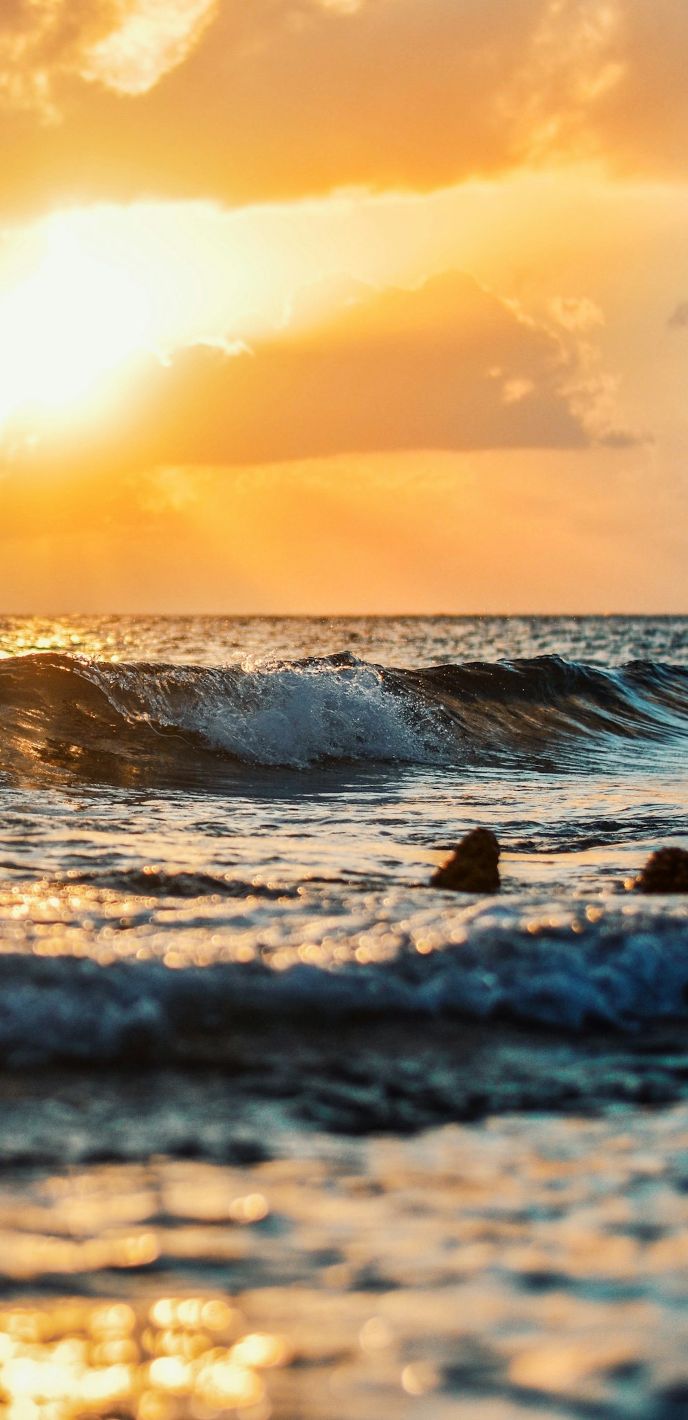 ocean waves crashing on shore during sunset