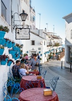people sitting on chairs near white concrete building during daytime