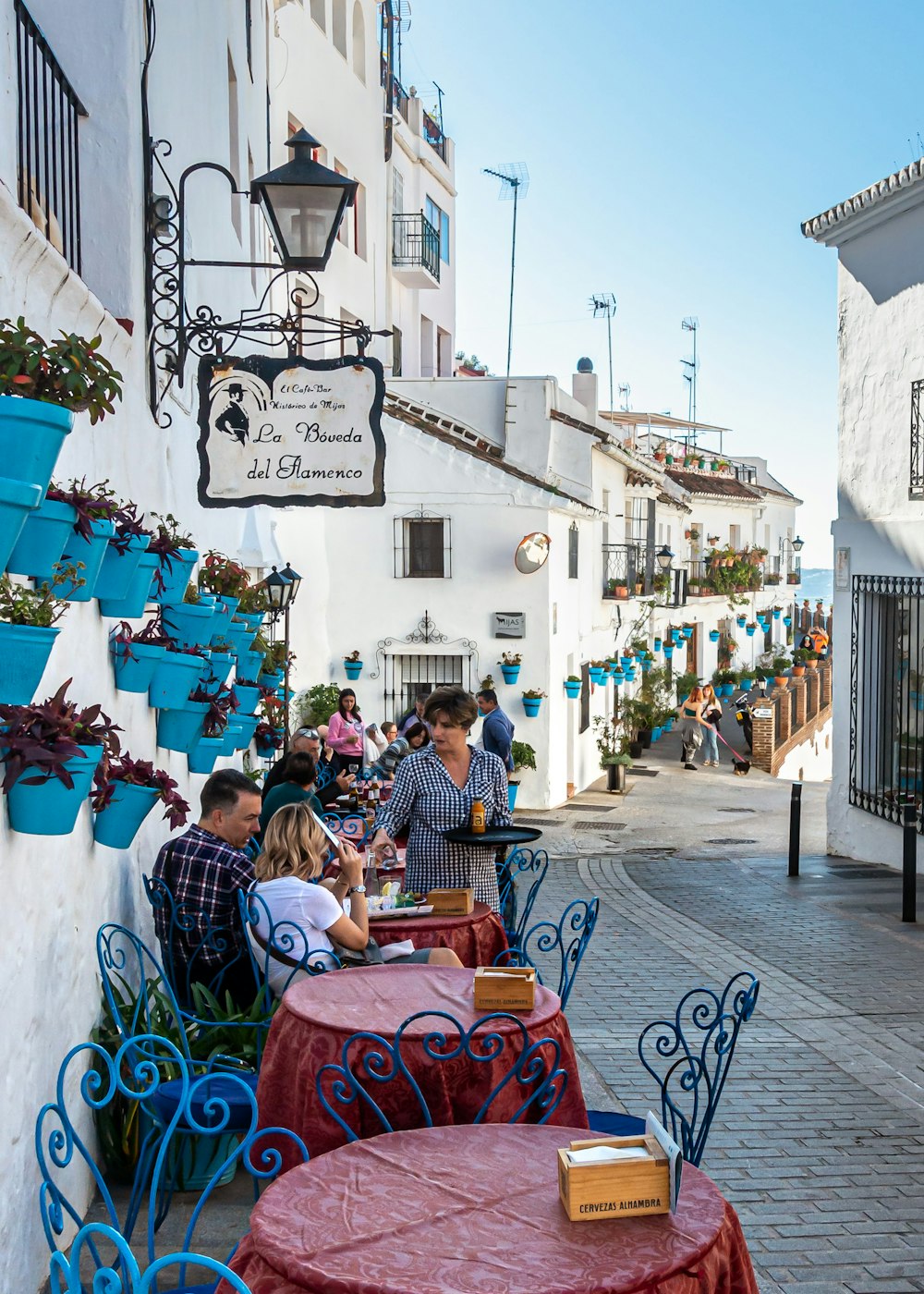 people sitting on chairs near white concrete building during daytime