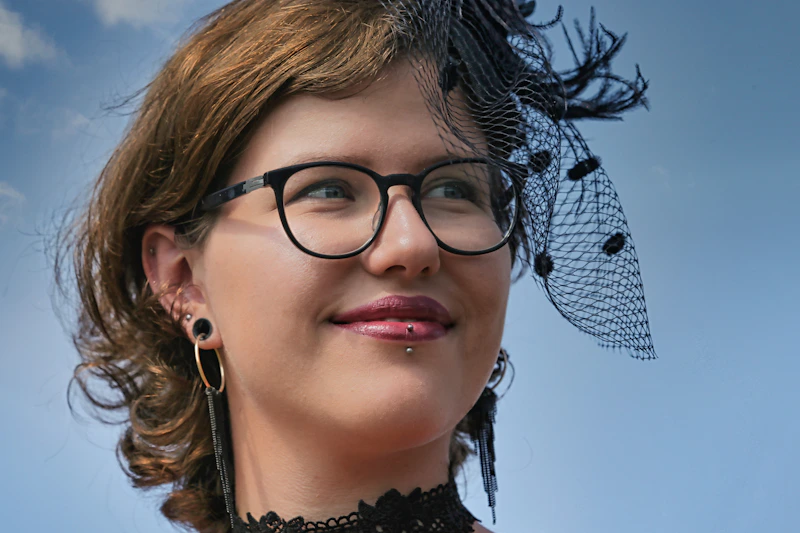 woman in black and white floral shirt wearing black framed eyeglasses