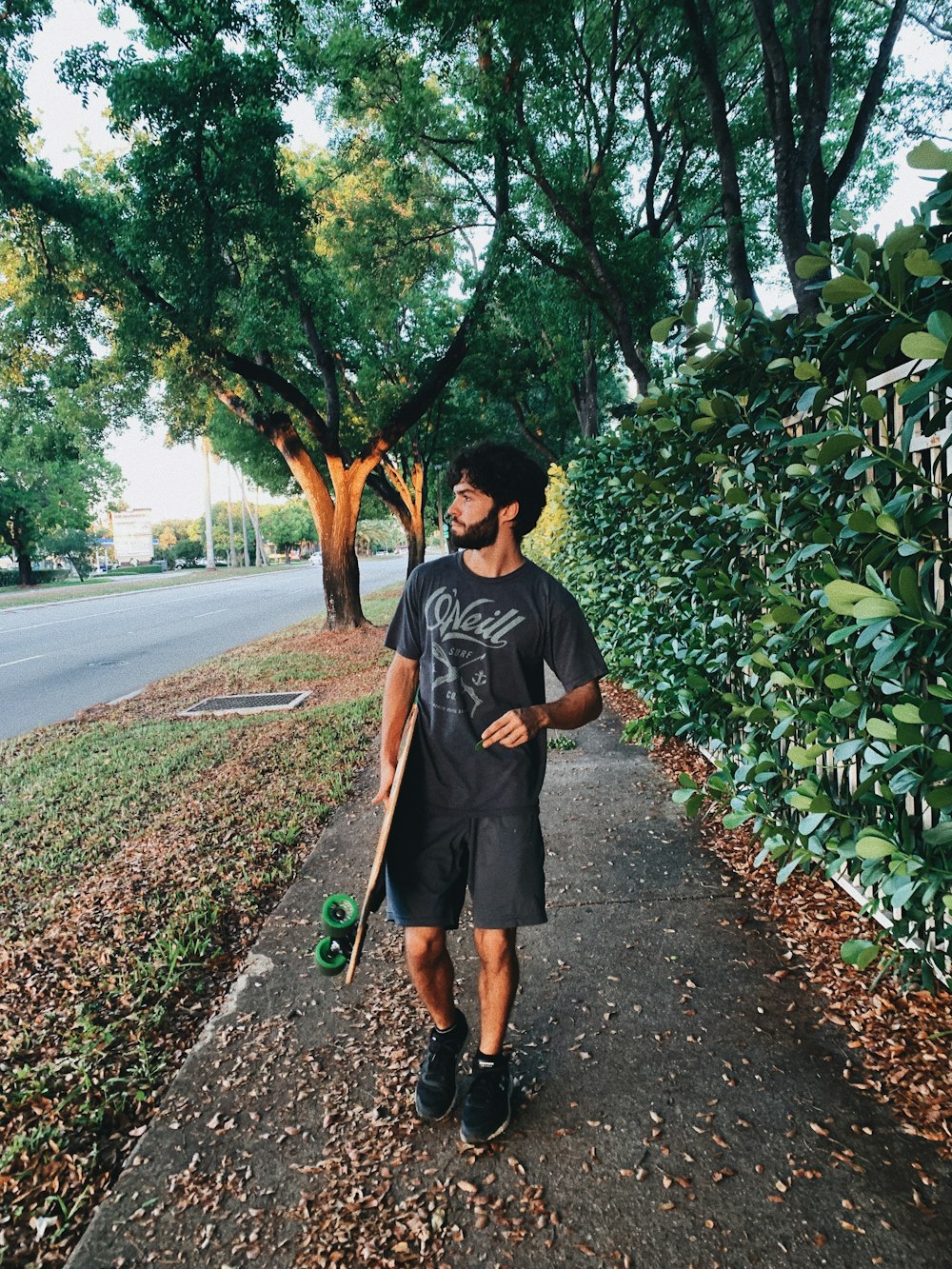 man in black crew neck t-shirt standing on road during daytime