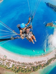 MG TURIZM A man in blue helmet riding on blue and white parachute