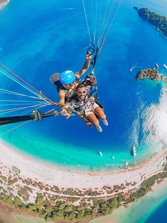 man in blue helmet riding on blue and white parachute in Fethiye Turkey
