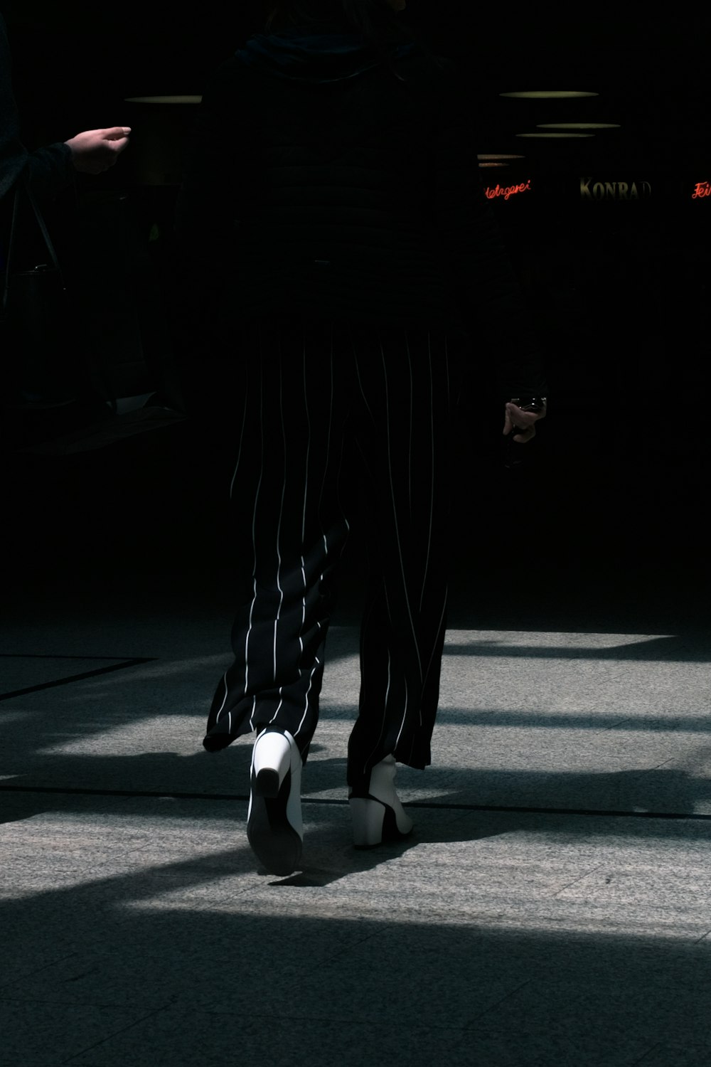 person in black pants and white shoes