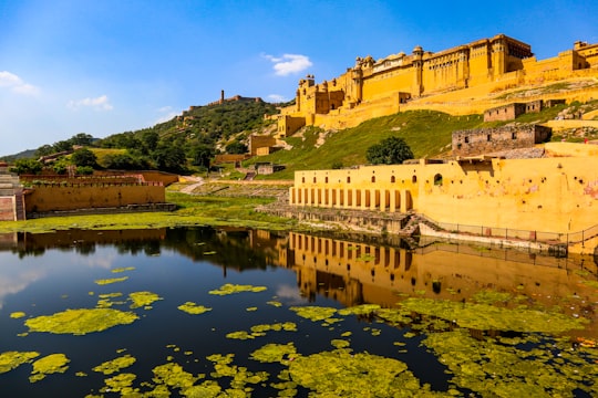 brown concrete building near river under blue sky during daytime in Rajasthan India