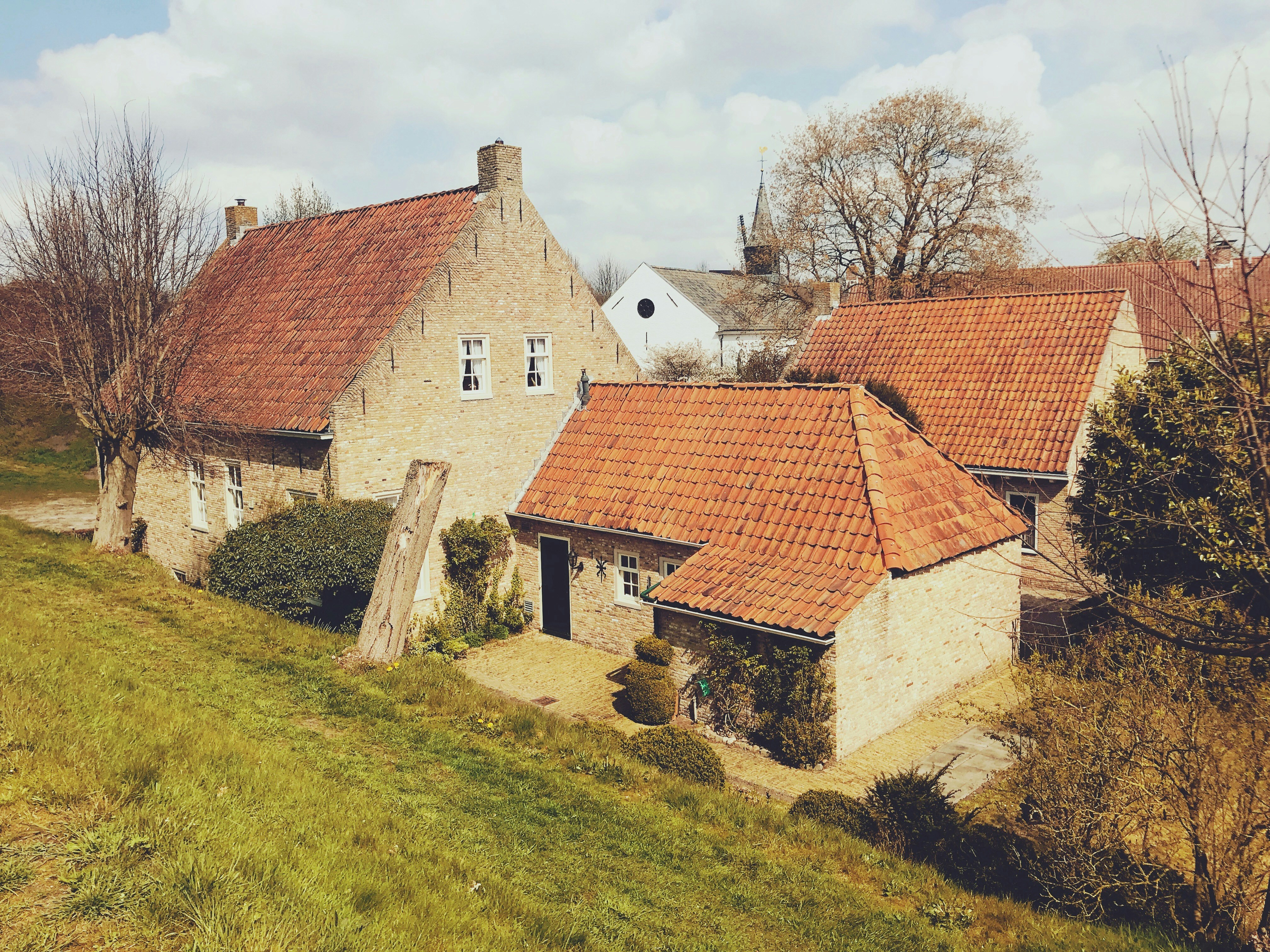 Braunes Backsteinhaus auf grünem Grasfeld tagsüber