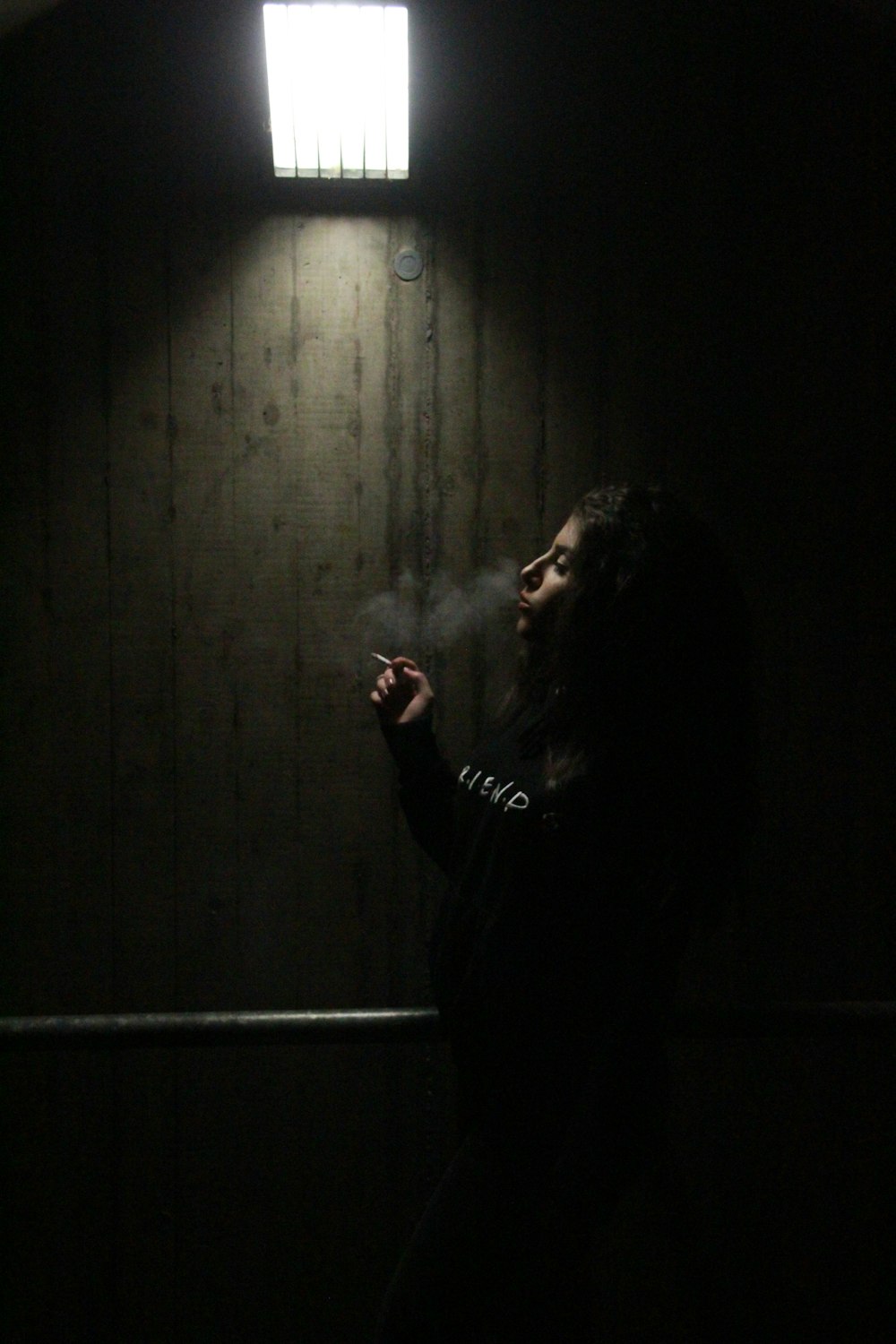 woman in black long sleeve shirt smoking cigarette