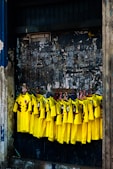 group of men in yellow and black long sleeve shirt standing beside brown concrete wall