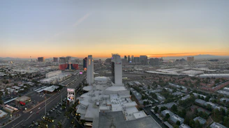 A cozy hotel room with a beautiful view of the city skyline at sunset.