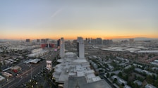 A scenic view of a city skyline at sunset from a hotel balcony.