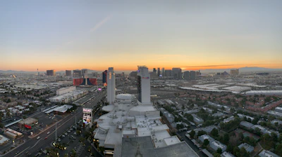 A cozy hotel room with a beautiful city view at sunset.