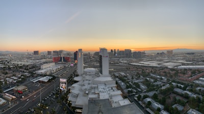 A scenic view of a cozy hotel room overlooking a vibrant city skyline at sunset.