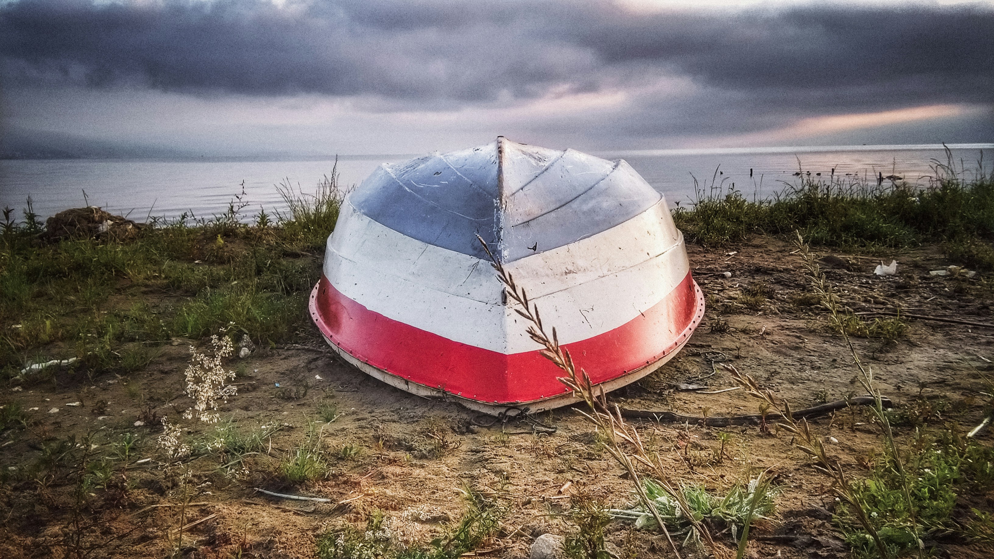 white and red boat on brown grass field under white clouds during daytime albania teams background