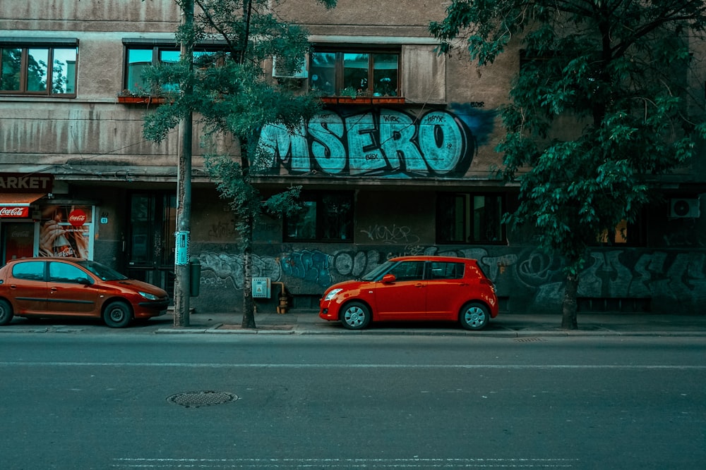 red car parked beside gray concrete building during daytime