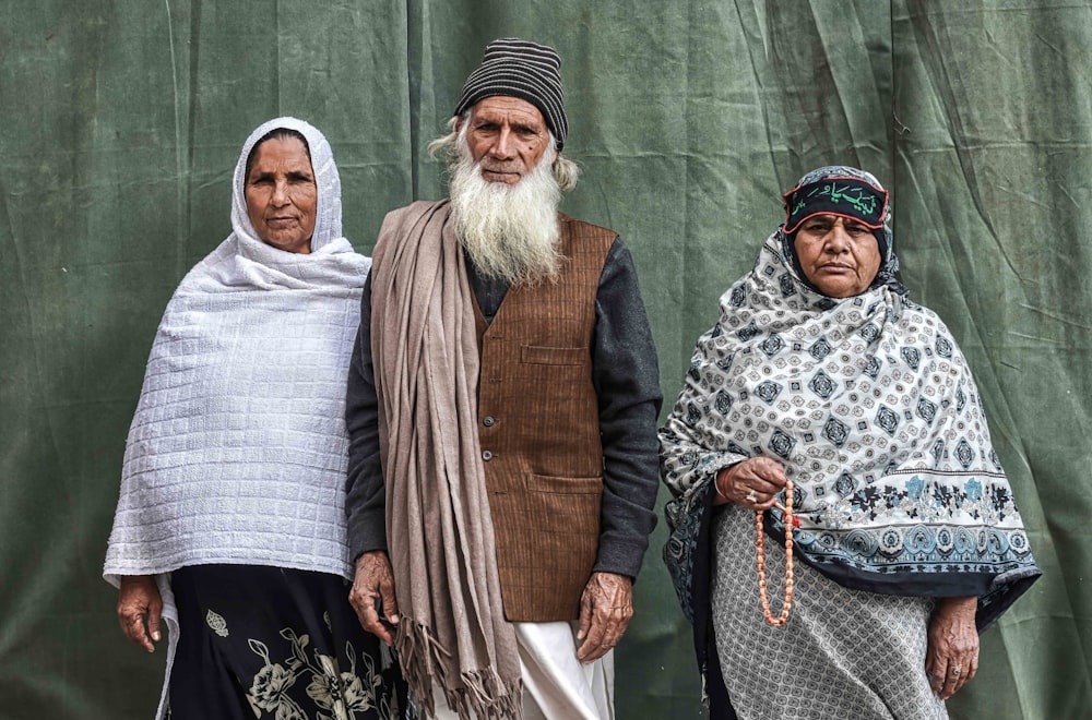 man in brown coat standing beside woman in white hijab