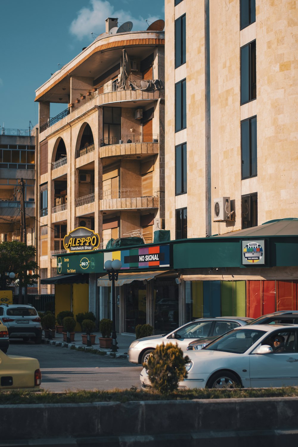 cars parked in front of brown building during daytime