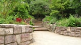 A serene garden path lined with pastel-colored flowers and natural stone steps.