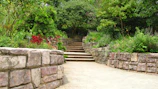A serene garden path lined with reclaimed flagstone, bordered by lavender and aged stone walls.