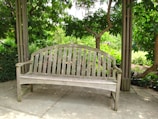 A cozy wooden bench placed in a serene garden setting.