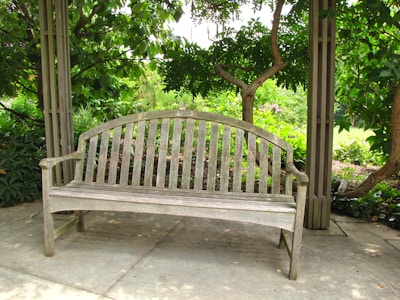 A cozy wooden bench placed in a serene garden setting.