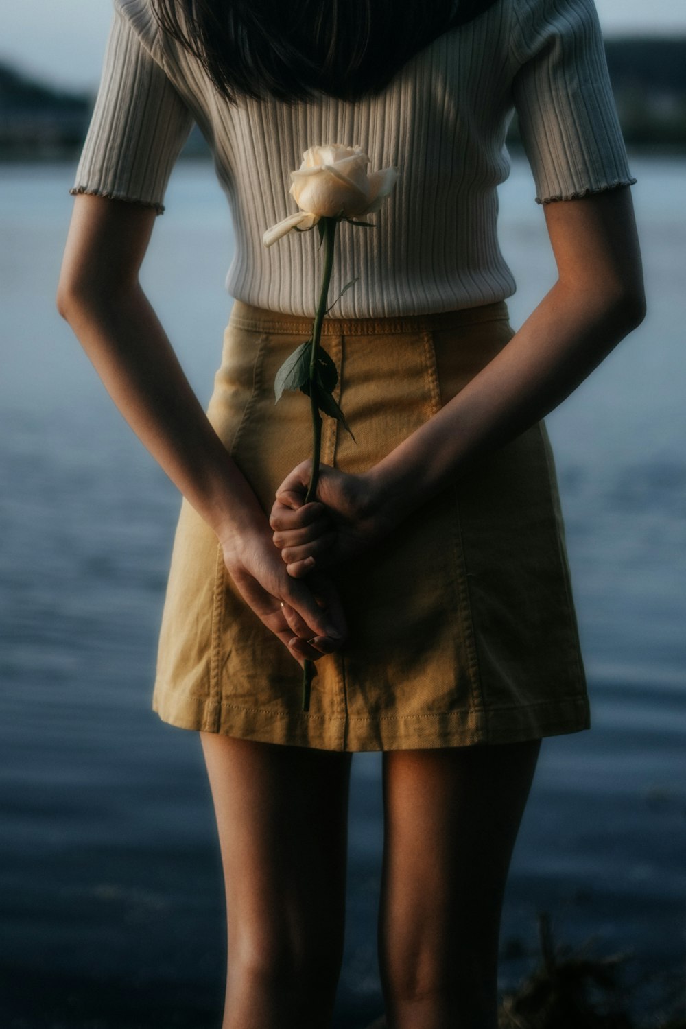 woman in white and black stripe shirt and brown skirt standing on beach during daytime