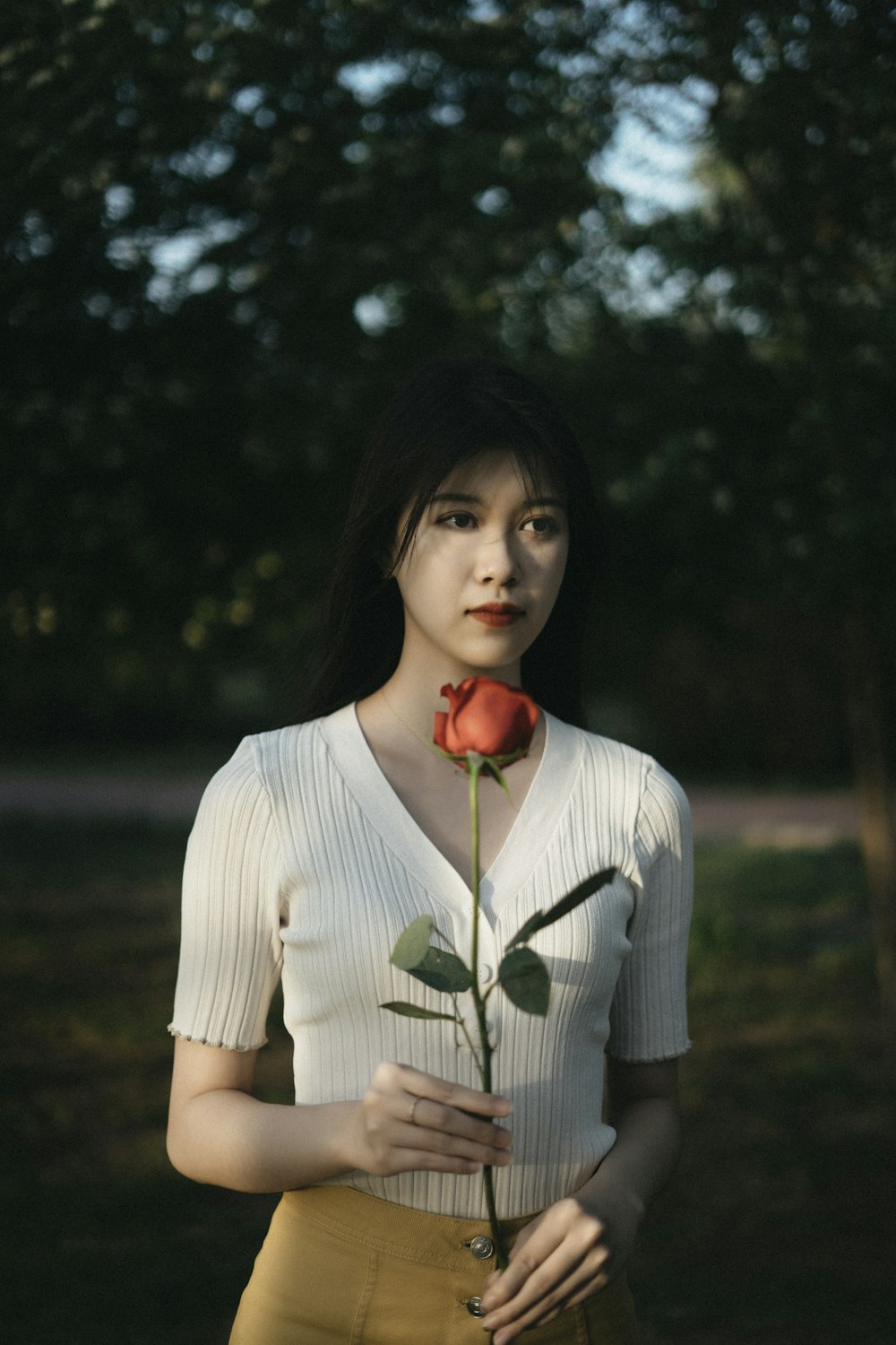 woman in white long sleeve shirt holding red cherry