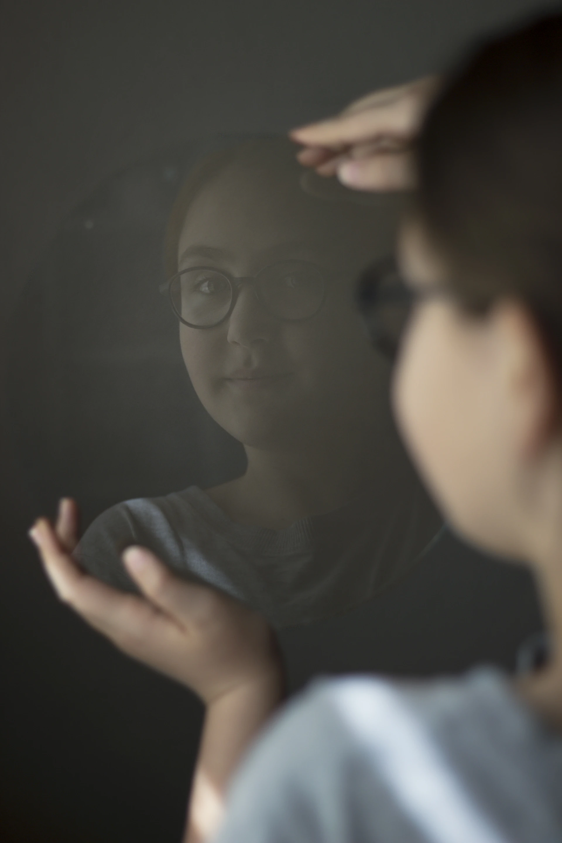 woman in black shirt looking at the mirror