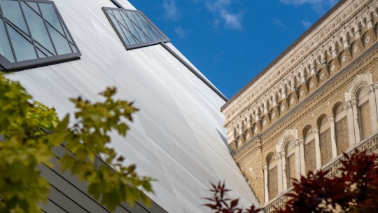 low angle photography of beige concrete building under blue sky during daytime in Royal Ontario Museum Canada