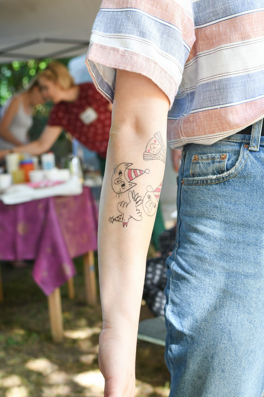 person in blue denim shorts with black and red dragon tattoo on right leg