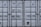 A close-up view of the doors of a shipping container. The surface is metallic with vertical reinforcement bars and stickers indicating information about weight in kilograms and pounds. Labels such as 'MAX. GR. TARE' and 'NET CU. CAP.' are present along with numerical values. The container has a standard industrial appearance.
