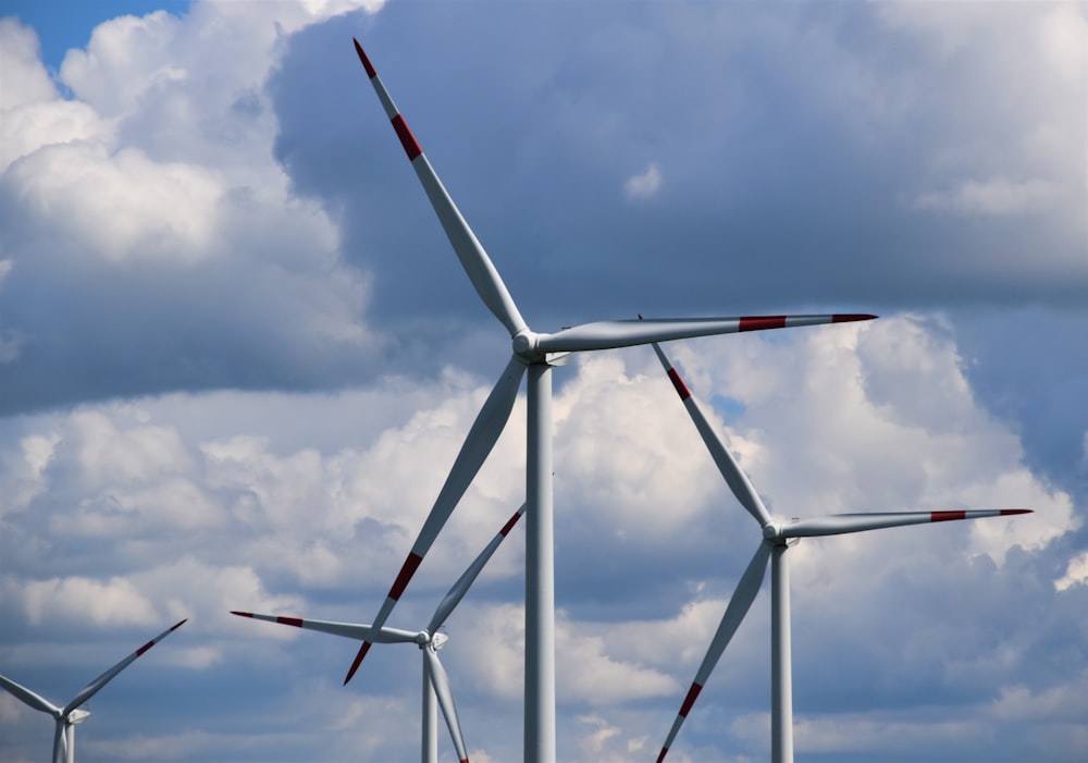 turbina eólica branca e vermelha sob o céu azul durante o dia