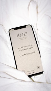 black samsung galaxy smartphone on white textile