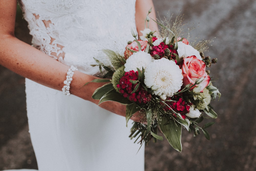 Mujer sosteniendo flores blancas y rosas