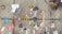 A variety of police and sheriff patches are attached to a chain-link fence. The patches include names like Louisville, Orange County, and Los Angeles County. There are also ribbons, wristbands, and small ornaments, including a white bow and a small baseball.
