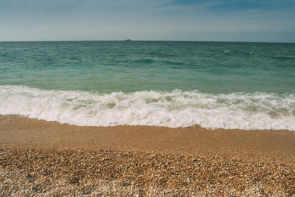 sea waves crashing on shore during daytime