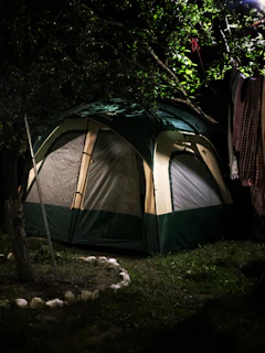green and gray tent on green grass field during daytime